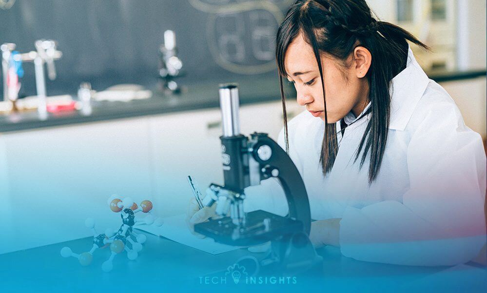 A young girl student in chemistry class with a microscope