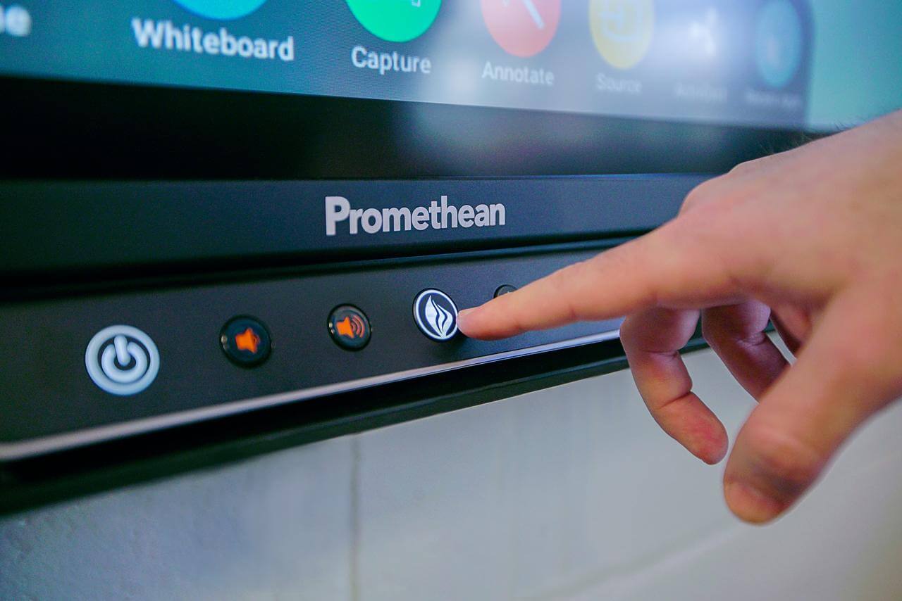 A hand presses the buttons on the ActivPanel